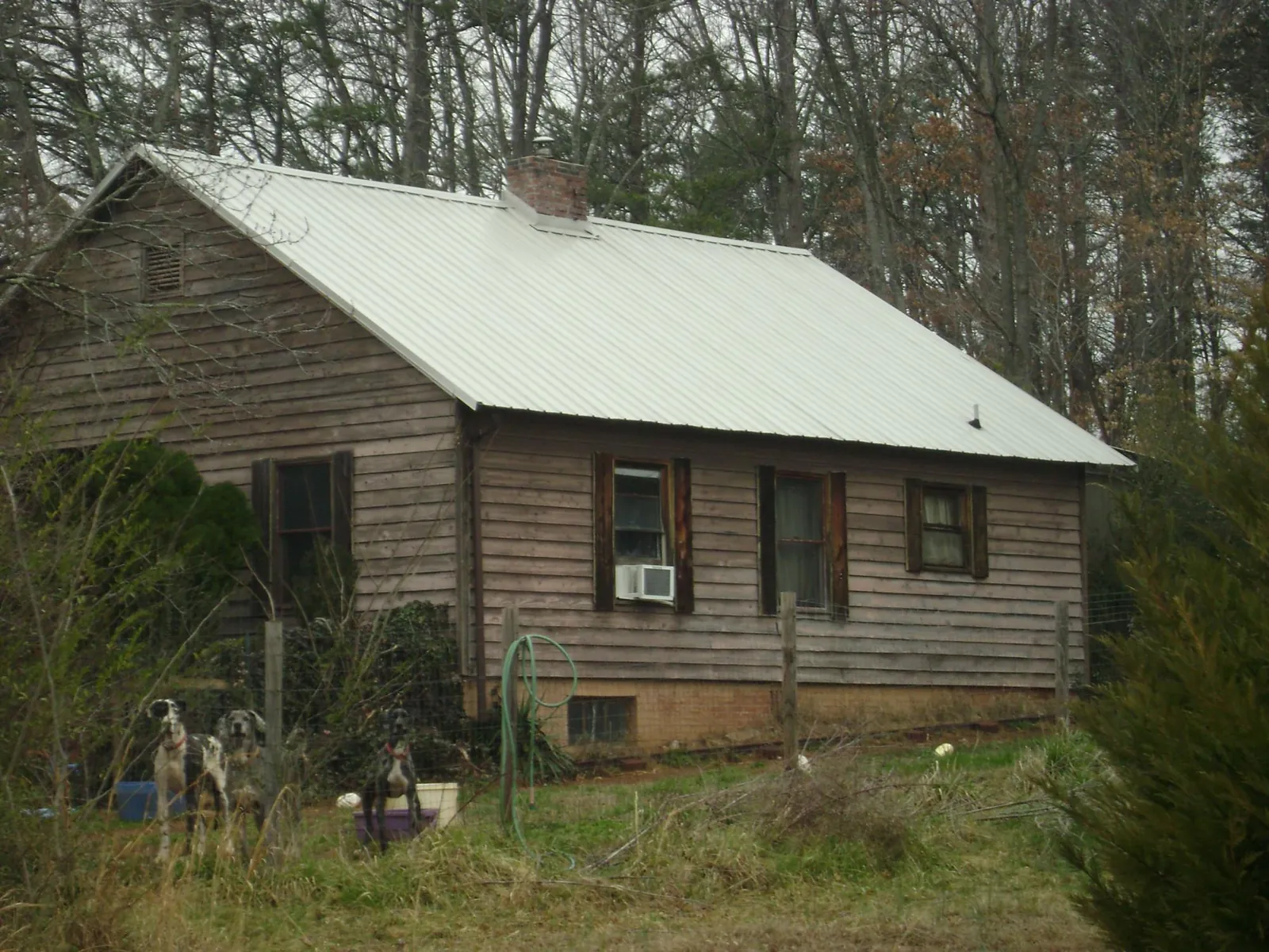 White metal roof on an old wood sided farmhouse, from a Metal Roof Installation job in Millwood